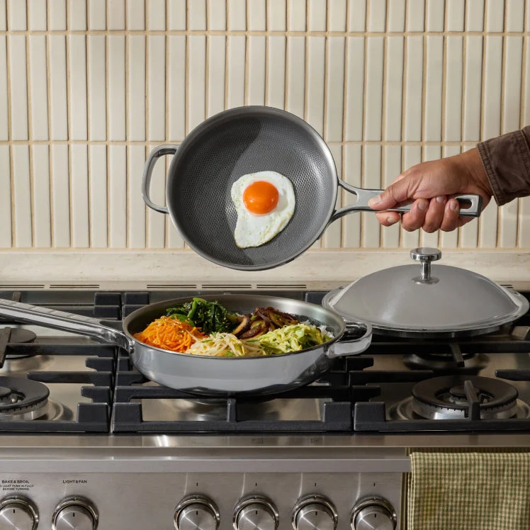 Titanium pan being preheated on a stove with oil coating the interior surface
