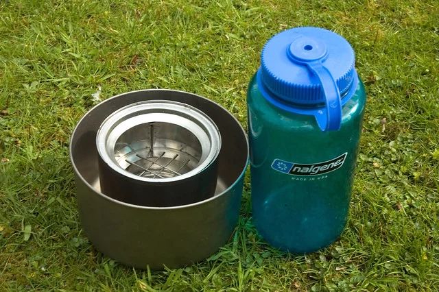 Batterie de cuisine de camping en titane : le guide complet sur ses points forts (et ses limites) 1 Casserole légère en titane posée sur un rocher de granit dans un campement de montagne – ustensiles de cuisine ultralégers pour la randonnée